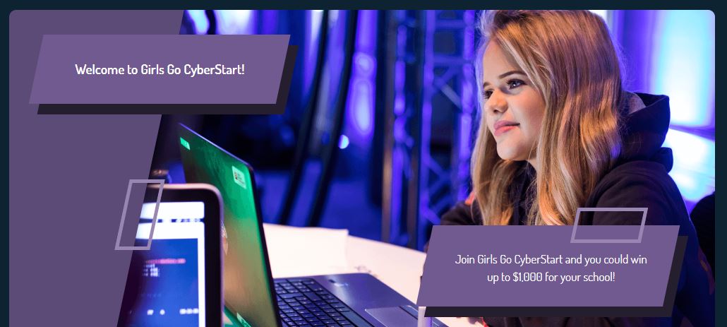 Image of a young girl working on a computer and smiling.
